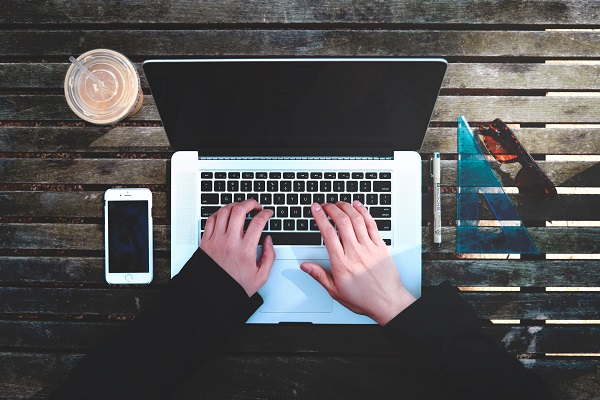 Hands typing on a laptop keyboard